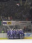 Chomutov�t� slav� v rohu kluzi�t�, n�kde uprost�ed t� zm�ti lze tu�it st�elce v�t�zn� branky - Zde�ka Sko�epu. Nad nimi slav� jejich fanou�ci.
